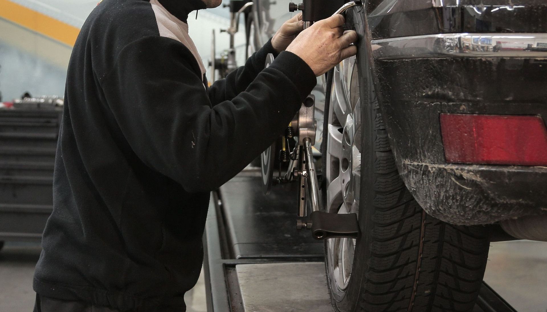 Professional mechanic adjusting wheel alignment for optimal performance in auto repair shop.